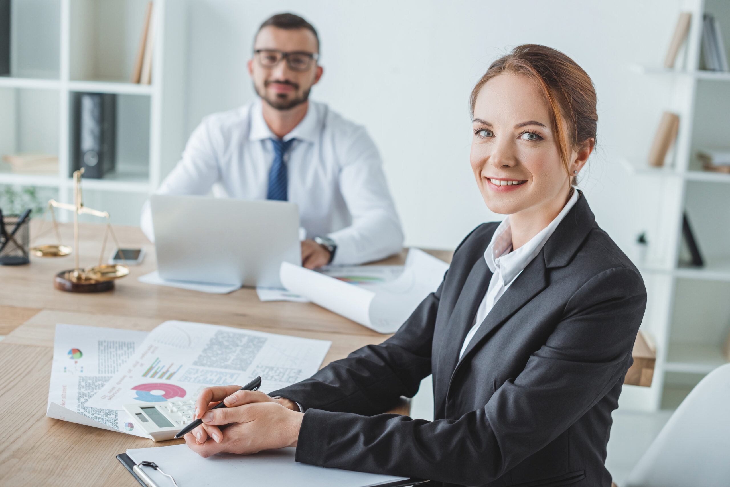 smiling financiers looking at camera in office