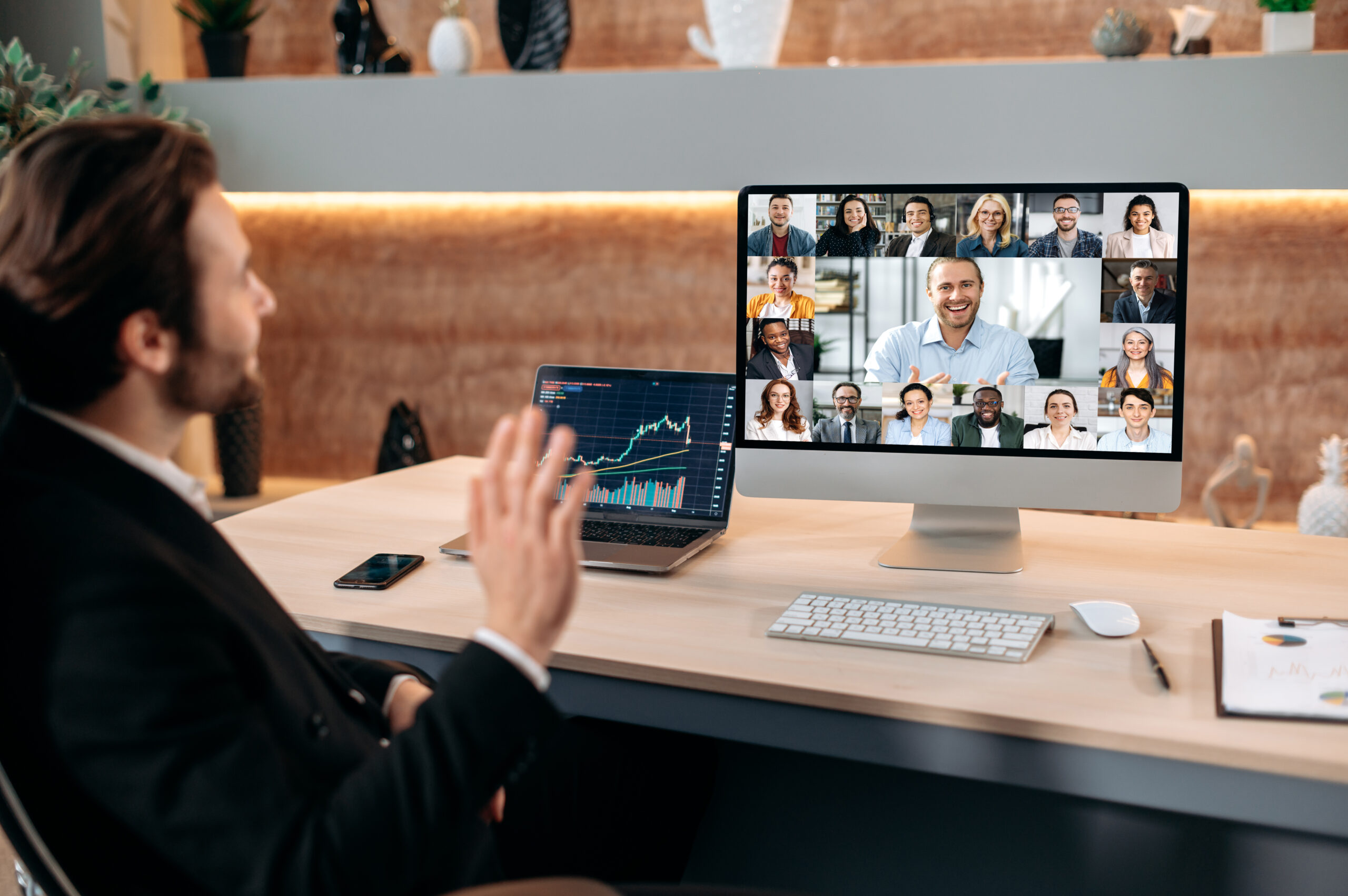 Video conference with business partners. Successful caucasian male stock broker sits in his modern office, talking on a video call with colleagues, working out a crypto strategy, discussing risks