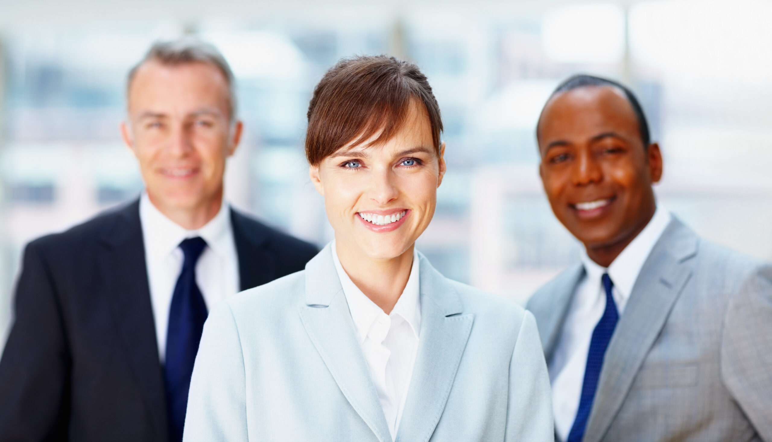 Successful female executive with colleagues in background.